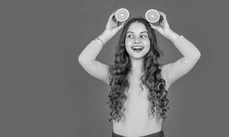 happy teen child hold orange fruit on pink background