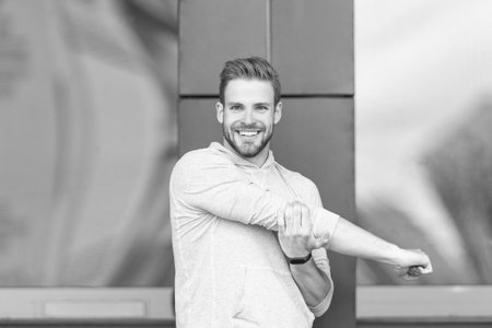 fitness man warming up in hoodie. fitness man in hoodie outdoor. fitness man in hoodie in the street. photo of fitness man in hoodie.の写真素材