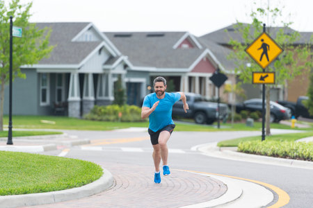 Runner at a long sport run. Runner sportsman running at full speed. Man sportsman running for exercise outdoor. In a morning sport workout jogger run. Hispanic athlete.の写真素材