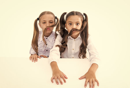 children girls wearing uniform. high school education. school education for girls. children girls on desk. ready for school lesson. two girls in school class. education and knowledge. having fun.の写真素材