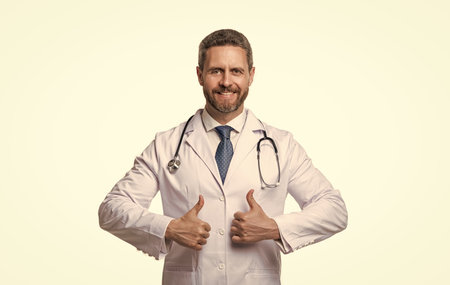 cardiologist showing thumb up in studio. cardiologist on background. photo of cardiologist man doctor. cardiologist isolated on white.の写真素材