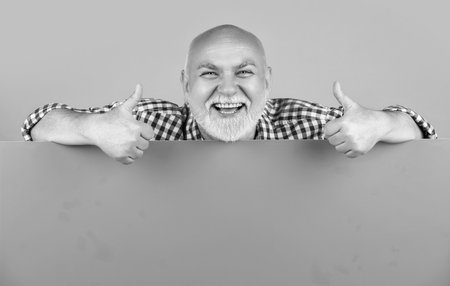 glad senior man with copy space on blank banner. thumb up.の写真素材