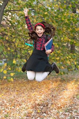 Back to school. Teen girl with homework jump in autumn. School education of girl. Knowledge and...