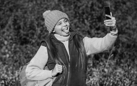 happy teen girl taking selfie with smartphone in autumn.