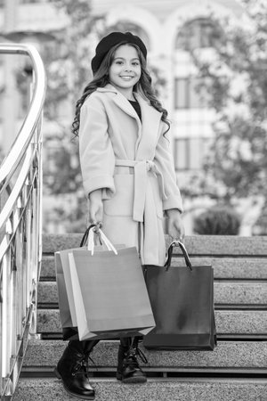 teen girl go shopping in autumn coat during sale holding purchase shopper bag outdoor.の写真素材