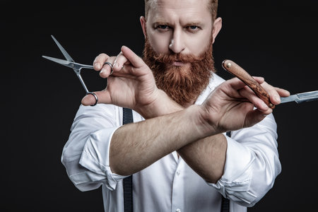 Man barber making a haircut in a barbershop. Great time at barbershop. Haircut by hairdresser at barbershop. Barber man. Man barber with razor blade do haircut. Professional skills.の写真素材
