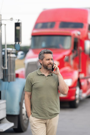 Mature man driver of truck talk on phone. Trucking owner. Truck driver has phone call. Man trucker driver at lorry truck. Semi trucks vehicle. Hispanic man trucker. Mobile communicationの写真素材