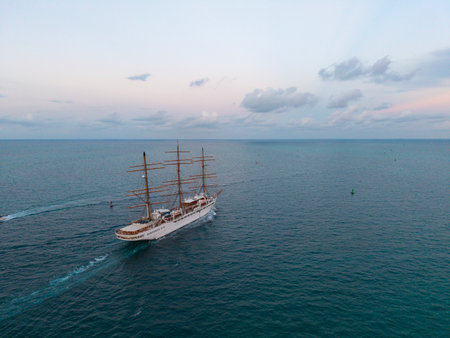 Ship sailing the sea. Sail oat at port of Miami. Travel by sea. Seascape horizon at sunset. Sea vacation. Sailboat vessel. Sail training ship. Sailing boat at dramatic sky seascape. Vessel tripの写真素材