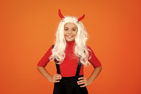 Girl devil ready for Halloween party isolated on orange. Trick or treat. All Hallows party celebration. All Hallows fun. Girl devil has Halloween party props. Happy Halloweenの写真素材