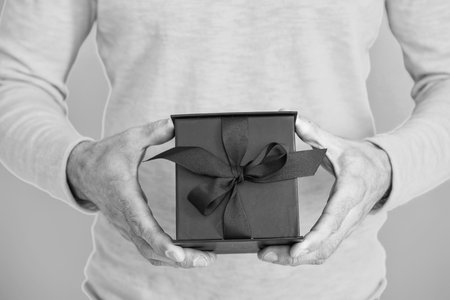 Mens day. Anniversary occasion. Romantic gift for the date. Present for mens day. Man on February 14. Man give present gift box for Valentines day. Happy Valentines day. Cropped viewの写真素材