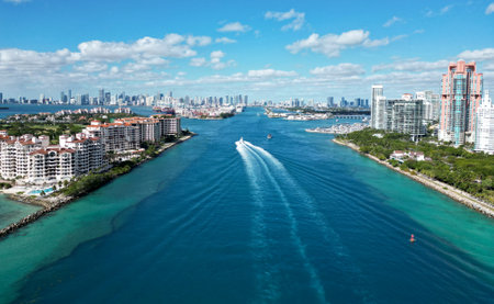 Miami south beach with motorboat passing canal between Fisher island and south pointe park heading to port marina, Floridaの写真素材