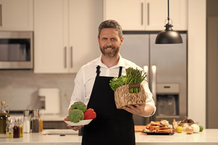 Hispanic man preparing food in kitchen. Man in kitchen. Healthy diet, vegetarian. Healthy food for...