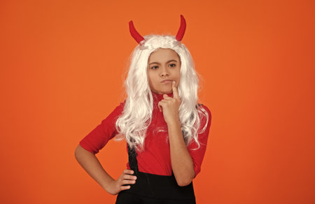 Girl devil has Halloween party props. Happy Halloween. Girl devil ready for Halloween party isolated on orange. Trick or treat. All Hallows party celebration. All Hallows fun. Think about mischiefの写真素材