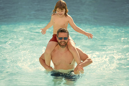 Father son beach adventure. Family bonding of father and son. Family day with dad and son. Father with kid in swimming pool. Fatherhood at summer vacation. Summer vacation at pool. Travel destinationの写真素材