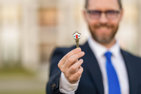 House key. Man buy house for investment purpose. Property insurance services. Ownership. Selective focus and copy space. Real estate agent sell property. Realtor holding keyの写真素材