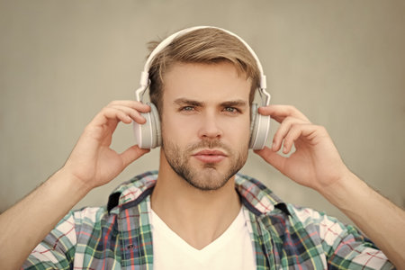 Modern lifestyle. Student life. Listen to music in headphones. Man millennial generation listen...