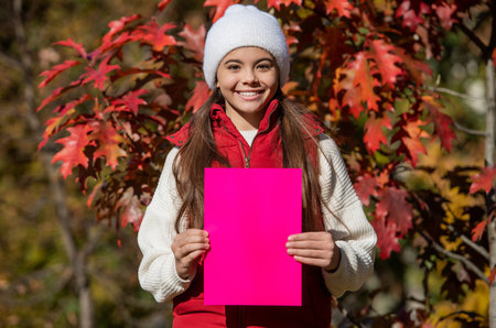 teenager girl suggest something on blank paper with copy space. autumn girl make a suggestion....