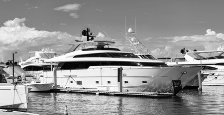 Luxury lifestyle. Vacations on summer. Yacht at sea port. Luxury boat motor yacht in marina on Biscayne Bay. Sailboat moored to pier in yacht marina. Sailing and yachting tourism. Yacht charterの写真素材
