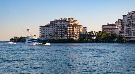 Luxury yacht boat at Fisher island. Summer vacation. Fisher island residential building and luxury yacht boat. Motorboat passing Fisher island, Miami. Miami architecture, Florida. Touristic landmarkの写真素材