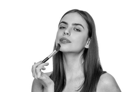 Woman do make up using cosmetic brush. Skincare cosmetic. Applying makeup on healthy skin. Beauty makeup products. Young woman powder brush for makeup. Girl doing makeupの写真素材