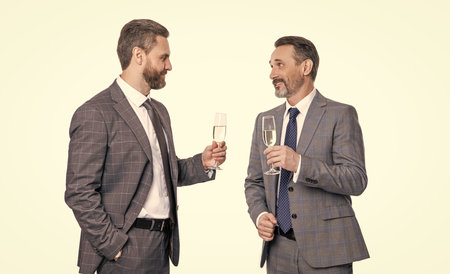 partnership and business success. businessmen isolated on white. successful business partnership. two successful businessmen partner celebrating business success with champagne. cheeringの写真素材