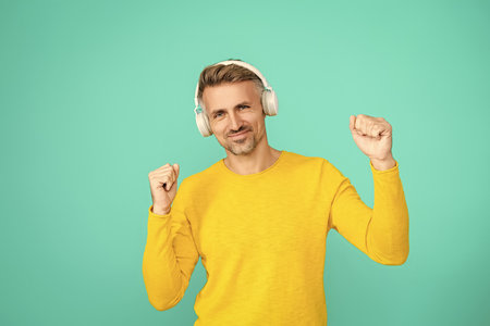 Music concept. Modern lifestyle. Man listening audio in music headphones. Caucasian man isolated on...