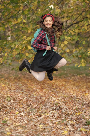 Teen girl in jump autumn park outdoor. Knowledge and education. School education. Student life. Back to school. Autumn girl jump with school bag. Fall moodの写真素材