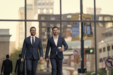 Business talking. Two businessmen in elegant business suit. Walking colleague. Colleague and friends. Two successful business men walking outdoor. Businessmen go to work. New opportunitiesの写真素材