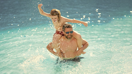 Travel in summer. Sea beach vacation. Son child having fun with his father. Pool time. Fathers day. Parenthood. Summer vacation of happy family. Father and son in swimming pool. Beach vacationの写真素材