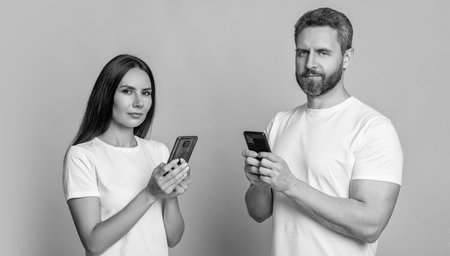 Messaging and texting. Connected online. Chatting on phone. Couple chat online. Family couple blogging. Modern phone communication. Woman and man blogging using smartphone. Digital love notesの写真素材