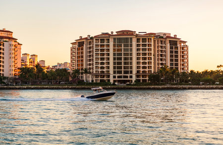 Vacation on summer. Fisher island building. Luxury motor boat yacht. Yacht go to marina. Boating and yachting. Luxury life. Yacht at Fisher island luxury residential buildingの写真素材