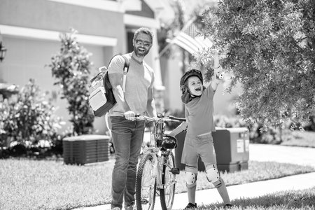 father and son cycling at sunlit park. creating memories. father and son navigate the winding paths together. father and son promenade. father and sonの写真素材