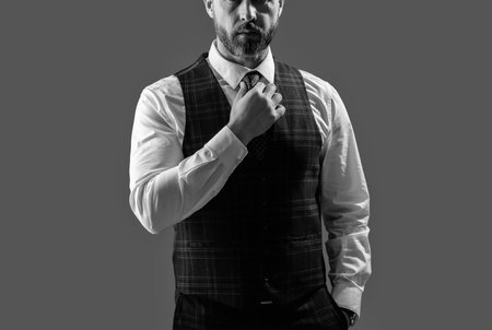 Gentleman menswear. Bespoke suit. Formal menswear concept. Man businessman in formalwear, cropped view. Business man in elegant tailored vest. Formal suit vest with tie isolated grey. Formal Occasionの写真素材