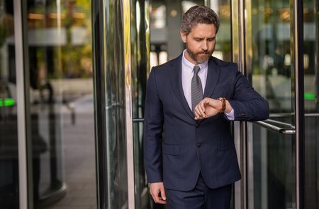 Businessman late for business deadline. Time management. Punctual man check time on watch being late. Waiting for colleague. Punctual businessman checking time outdoor. Business deadline. Copy spaceの写真素材