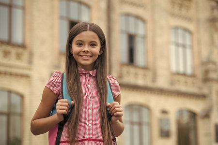 Girl pupil with bag at secondary school outdoor. Study time. September 1. College education. Back to school. Teen girl with backpack going to school. Education and knowledge. Student engagementの写真素材