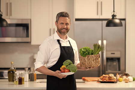 Healthy diet, vegetarian. Healthy food for dinner. Hispanic man preparing food in kitchen. Chef man...