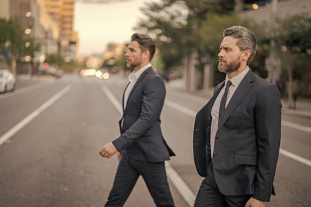Businessmen in suit walk outdoor. Success. Walk to success. Two businessmen walk in the city....