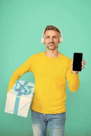 Mobile App For Smartphone. Man with box show screen. Delivery man with box. Fast phone delivery. Man...