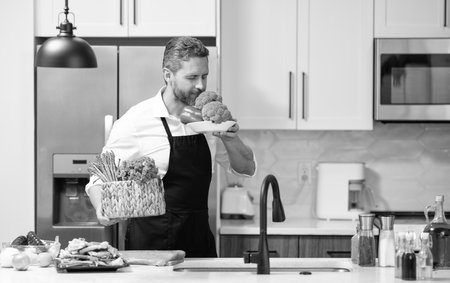 Man cook tasty meal. Home menu with fresh food ingredient. Man cook cooking at kitchen. Hispanic man...