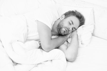 Deep male sleep. Man sleeping at night. Sleepy man lying on bed sleeping at white bedroom. Asleep...