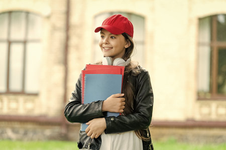 September is school time. September 1. Knowledge and education. Knowledge day in September. Girl in cap hold school homework. Back to school. Teen girl with homework outdoorの写真素材