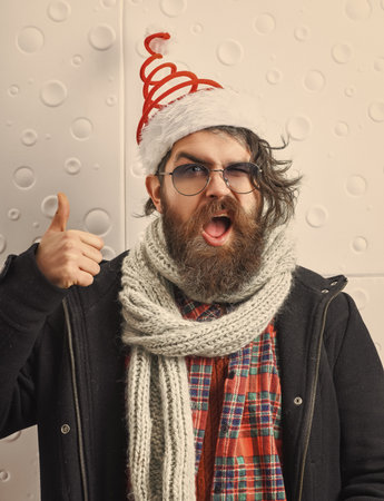 Merry Christmas. Santa Claus bearded man. Happy New 2025 Year. Xmas holiday celebration. Christmas afterparty. Brutal homeless man celebrate Xmas. Thumb upの写真素材