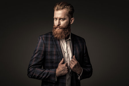 Suit on menswear model. Stylish man in business suit. Businessman with beard. Brutal bearded man isolated on grey. Ambitious man in elegant suit menswear. Formal fashion for man. Tuxedo jacketの写真素材