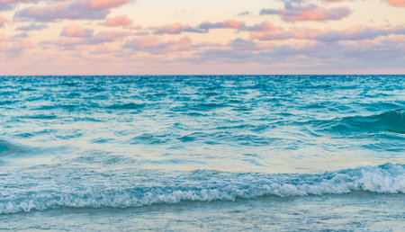 Skyscape with sea horizon. Calm horizon view at sea sunrise. Romantic summer vacation sunrise on seascape. Sea horizon view. Cloudy sky and seascape at summer vacation. Sea wavesの写真素材