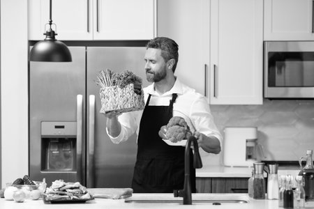 Hispanic man standing in kitchen preparing food. Organize before cooking. Man cook healthy salad. Food diet. Man cook a tasty meal. Home menu with fresh food ingredient. Man cook cooking at kitchenの写真素材