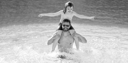 Summer vacation of happy family. Father and son in swimming pool. Travel in summer. Sea beach...