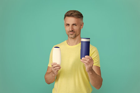Offer aftershave. Presenting cosmetics product for men. Man hold aftershave. Man with unbranded...