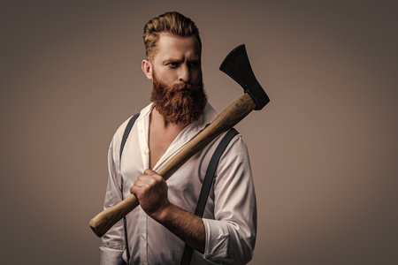 Masculine energy. Retro style. Handsome and charismatic. Masculine man. Masculinity of bearded man with axe isolated on grey. Caucasian brutal man with beard and moustache. Trendy hairstylingの写真素材