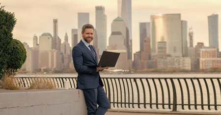 Business man typing on laptop in New York. Business man working online. Successful businessman freelancing online. Business success. Businessman working on laptop outdoor. Secure fundingの写真素材