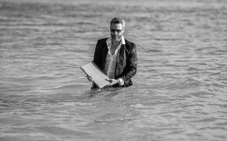businessman in suit remote working on laptop during the weekend and summer travel vacation
